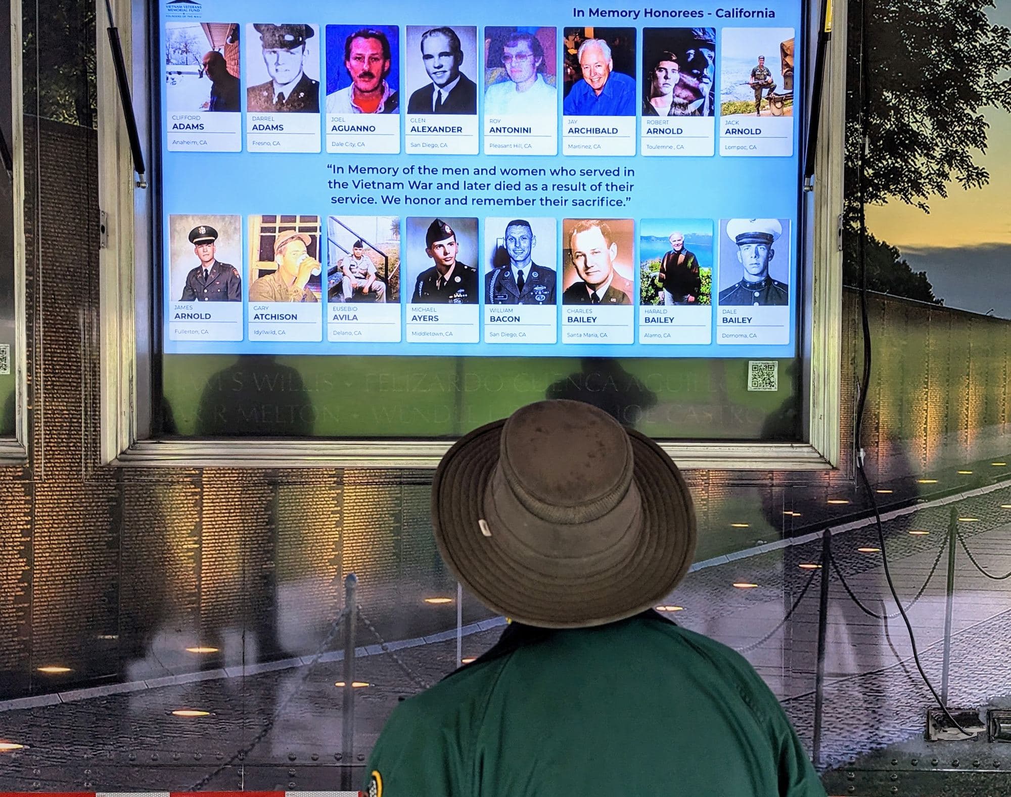 A visitor views the In Memory Honor Roll screen at the Mobile Education Center