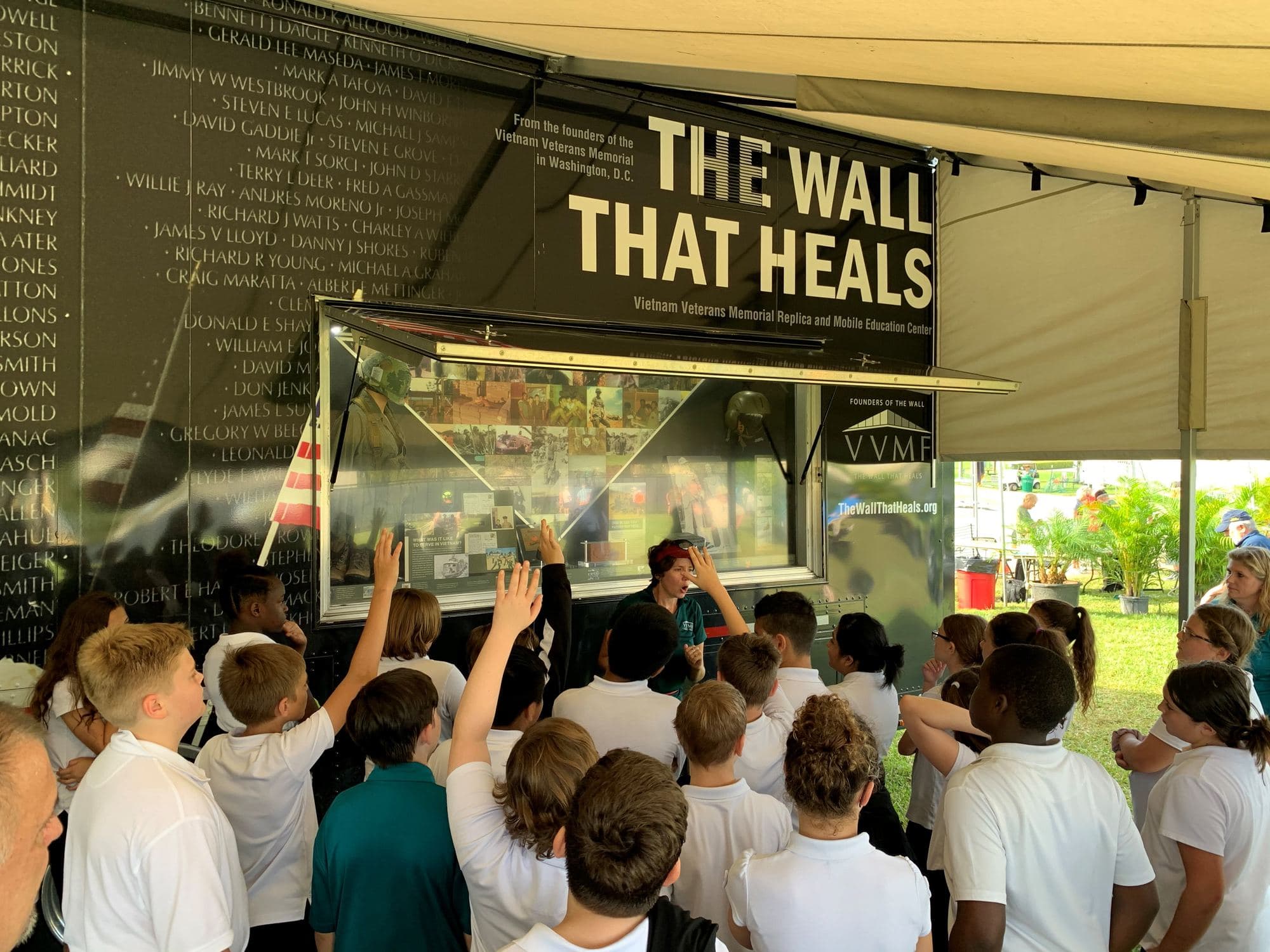 Elementary students raise their hands during a Mobile Education Center tour