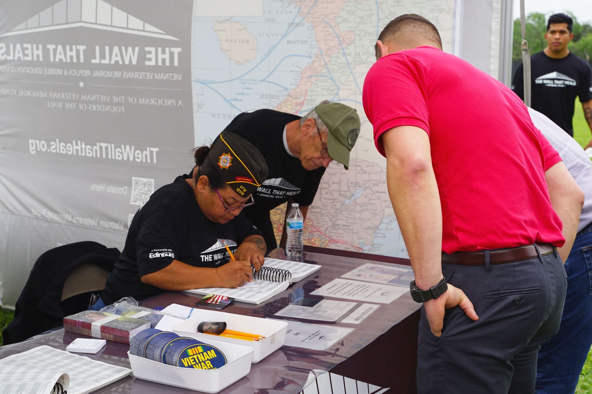 Volunteers help a visitor at the information tent