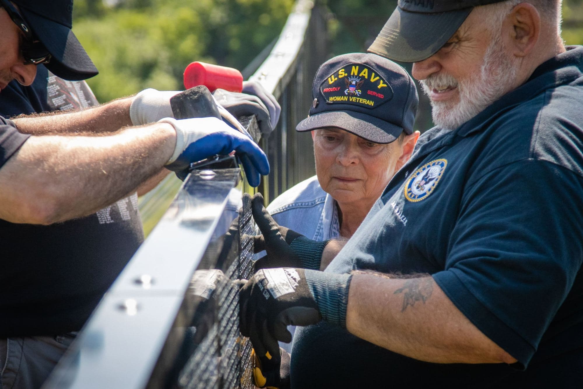 Volunteers steady support braces during setup of The Wall